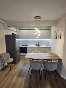 a kitchen with a table and chairs in a room at Royal Trip Luxury Apartment Sinaia in Sinaia