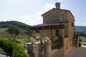 a small stone building with a balcony in a yard at Bea Villa Bea in Caldarola