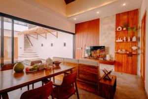 a living room with a dining room table and a television at Charming 2BR Retreat with Private Pool & Garden View in Dalung
