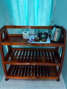 ein Holzregal mit einem Teeservice darauf in der Unterkunft Be Faanny House in Ko Lanta