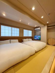 two large beds in a room with a tv at Rakuyu asakusa in Tokyo