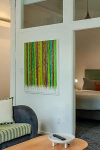 a painting of colorful yarn hanging on a wall at Modern 2-Bedroom Central City Apartment in Wellington