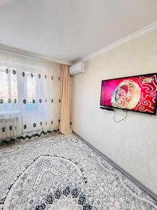 a room with a flat screen tv on the wall at Биржан Сал центр 2 к in Taldykorgan