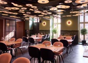 a restaurant with tables and chairs in a room at Entre Hotel by Zdrojowa in Wrocław