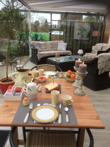 een houten tafel met borden en keukengerei erop bij Bed and Breakfast Ineke en John in Hoofddorp