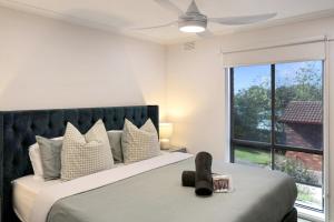 a bedroom with a bed with a teddy bear on it at Spa Haus Belmont- 2 King beds, Spa, Pets Welcome, Beaches, Golf, Shopping, Geelong in Belmont