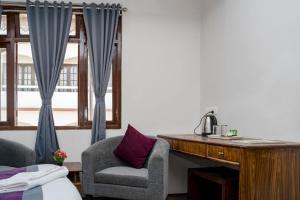 una camera con una scrivania, due sedie e un letto di Hotel Zi a Gangtok