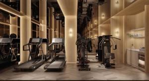 a gym with several treadmills and exercise bikes at Manevi Premier Hotel in Hanoi