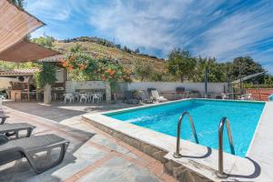 a swimming pool in a yard with a table and chairs at Casa Hitos in Monachil