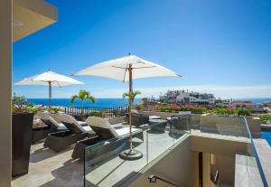 une terrasse avec des chaises et un parasol et l'océan dans l'établissement Villa Pacific West, à Cabo San Lucas