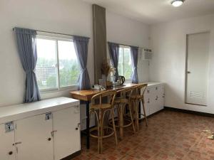 a kitchen with white cabinets and a wooden table with stools at Oceana Bay Coron in Coron