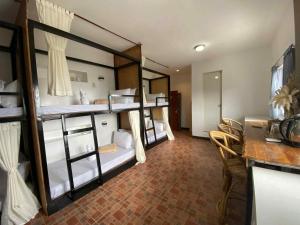 a room with four bunk beds and a table and chairs at Oceana Bay Coron in Coron
