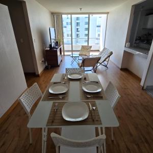 a dining table and chairs in a living room at Departamento Arequipa- PERUMIN 2025 in Paucarpata