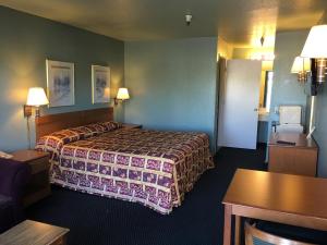 a hotel room with a bed and a table at Applegate Inn in Atwater