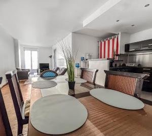 a dining room with a table and chairs and a kitchen at Le Balcon de la Comédie in Montpellier