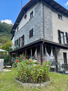 a large stone building with flowers in front of it at casa vacanza l'Oleandro in Poggiridenti +47 photos