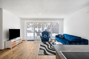 a living room with a blue couch and a tv at City Villa Bad Dürrheim EG in Bad Dürrheim