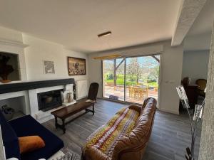 Una sala de estar con un sofá y una chimenea. en Le Koutoucou, en Douelle
