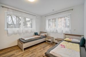 a bedroom with two beds and two windows at City Villa Bad Dürrheim Oberge in Bad Dürrheim