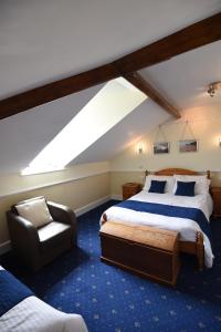 a attic bedroom with a bed and a chair at No.18 in Lowestoft