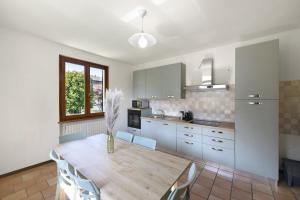 a kitchen with a table with chairs and a vase on it at Villa Arcadia Apartments in Vobarno