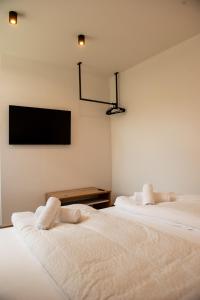 a bedroom with two beds and a tv on the wall at myQuartier Urban Residences digital self check in in Innsbruck