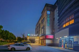 Un coche blanco aparcado delante de un edificio en Hanting Hotel Shanghai Pudong Airport Shixin Road, en Shanghái