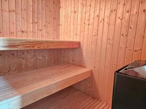 a wooden shelf in a sauna with a stove at FAN074-Fano-Kystvejen-13 in Fanø