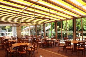 a restaurant with wooden tables and chairs and windows at Hotel Forum - Free Parking for cars in Sofia