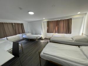 a room with three beds and two chairs in it at Milano Wandsbek City in Hamburg