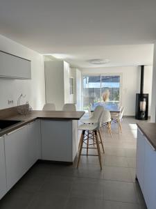 a kitchen with white cabinets and a table and chairs at La gildasienne in Saint-Gildas-de-Rhuys