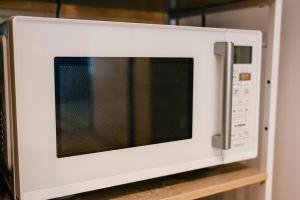 a white microwave oven sitting on top of a shelf at 古民家宿 孫八 - Mago8 in Maibara