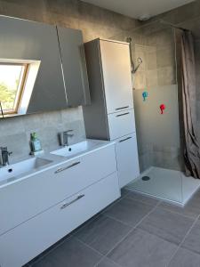 a white bathroom with two sinks and a shower at La gildasienne in Saint-Gildas-de-Rhuys