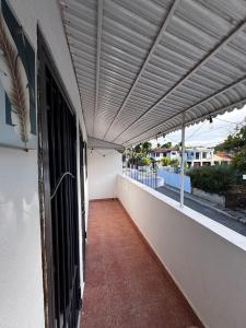 un balcón con toldo en el lateral de un edificio en Alojamiento el Reloj completo, en San Fernando de Monte Cristi