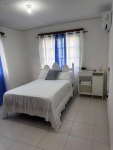 Un dormitorio con una cama blanca y una ventana. en Alojamiento el Reloj completo, en San Fernando de Monte Cristi 37 fotos más