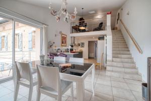 a dining room with a table and chairs and a staircase at La Demeure De Jeanne in Cadours