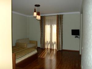 ein Wohnzimmer mit einem Sofa und einem TV in der Unterkunft Centrale Guesthouse in Dschermuk