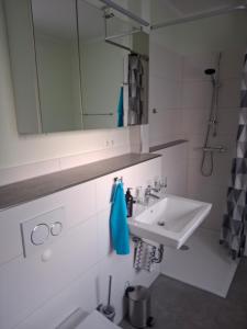 a white bathroom with a sink and a mirror at Fewo im Fränkischen Seenland in Untereschenbach
