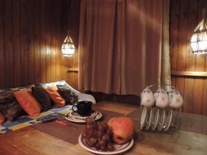 a table with a plate of fruit and a drink at Cabana Verde Rosa in Barra de Ibiraquera