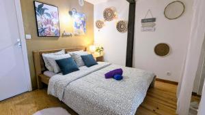 a bedroom with a bed with a purple stuffed animal on it at Cosy Leaf Planta - 1 Chambre - HyperCentre - in Pau