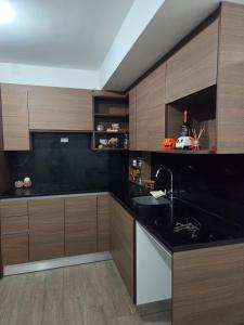 a kitchen with a black counter top and wooden cabinets at Aparhotel Monch in Guatemala