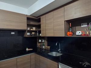 a kitchen with wooden cabinets and a sink at Aparhotel Monch in Guatemala