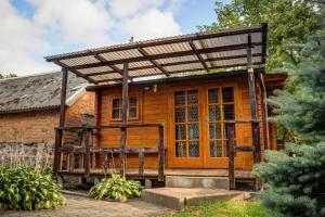 a wooden house with a pergola at Vila Aura in Šventoji