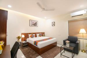 une chambre d'hôtel avec un lit et un bureau dans l'établissement FabHotel Prime Cozy - Nr Yashoda Hospital, Hitech City, à Hyderabad