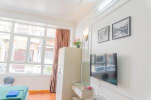 een woonkamer met een koelkast en een raam bij The Lake Silk Hanoi Boutique Hotel & Spa in Hanoi