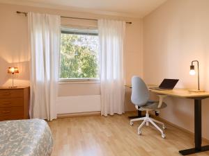 a bedroom with a desk and a bed and a window at Spacious 3-Room Flat in Martinlaakso in Vantaa