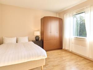 a bedroom with a bed and a dresser and a window at Spacious 3-Room Flat in Martinlaakso in Vantaa