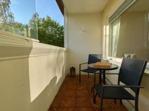 a balcony with two chairs and a table and a window at Spacious 3-Room Flat in Martinlaakso in Vantaa