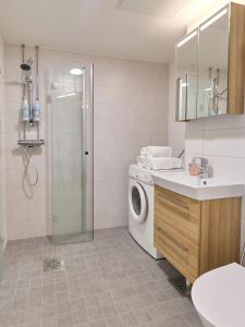 a bathroom with a washing machine and a sink at Spacious 3-Room Flat in Martinlaakso in Vantaa