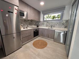 a kitchen with a stainless steel refrigerator and a window at Villa Amalia 25 Phase II in Torrevieja
